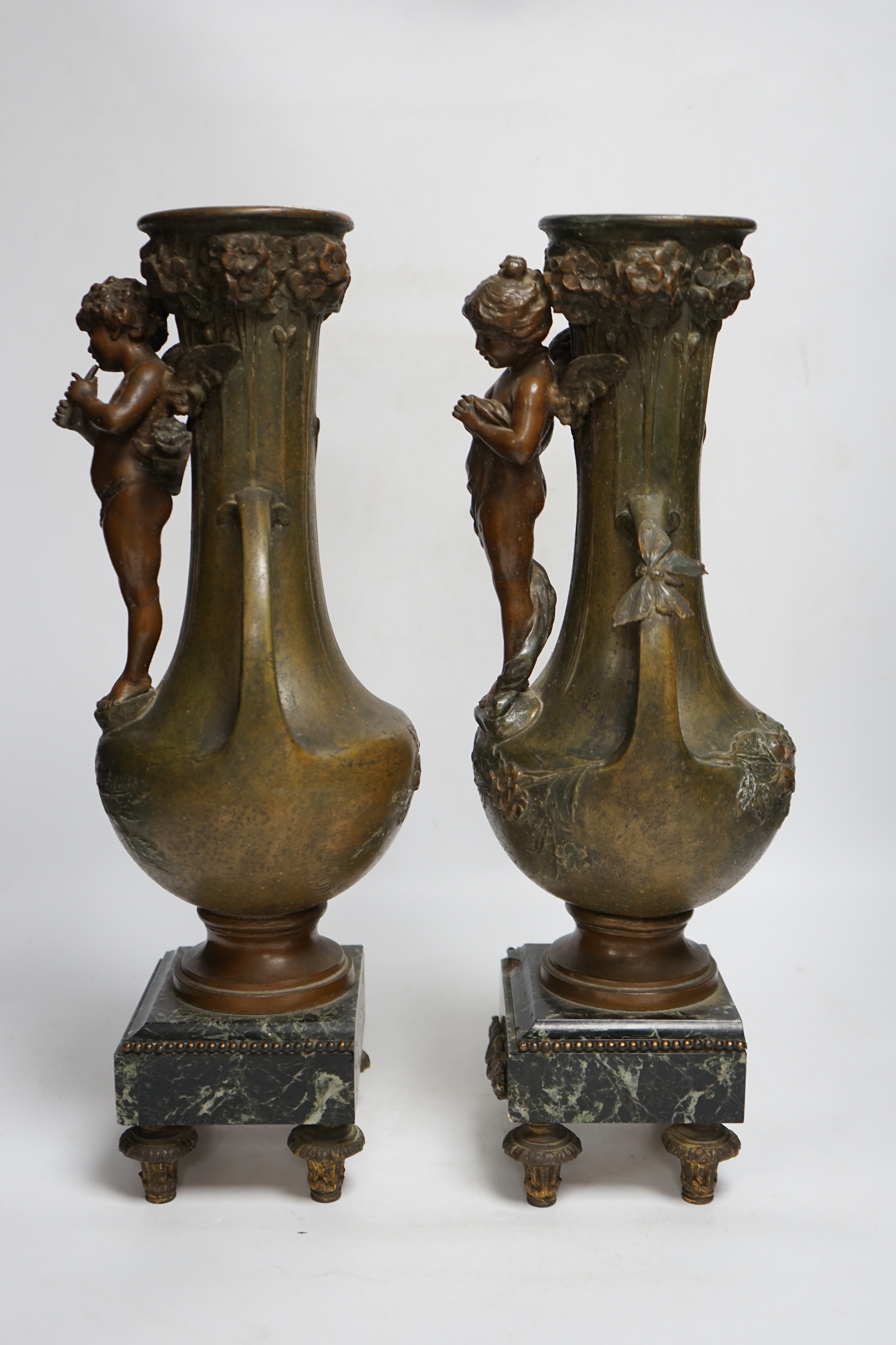 After Hippolyte François-Moreau (1832-1927), a pair of bronzed spelter cherubic vases on marble bases, 42cm